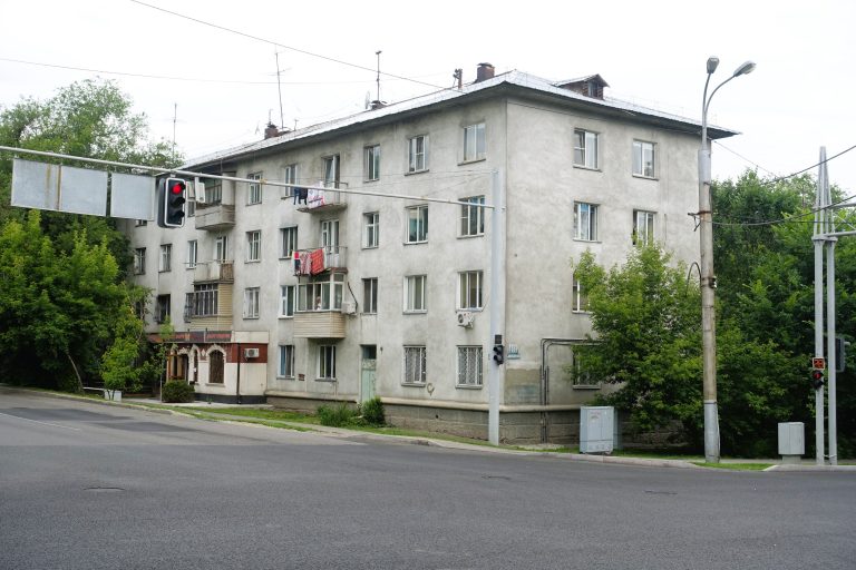Typical scene: grey or brown concrete blocks, with a random shop/restaurant/bar nestled on ground level.